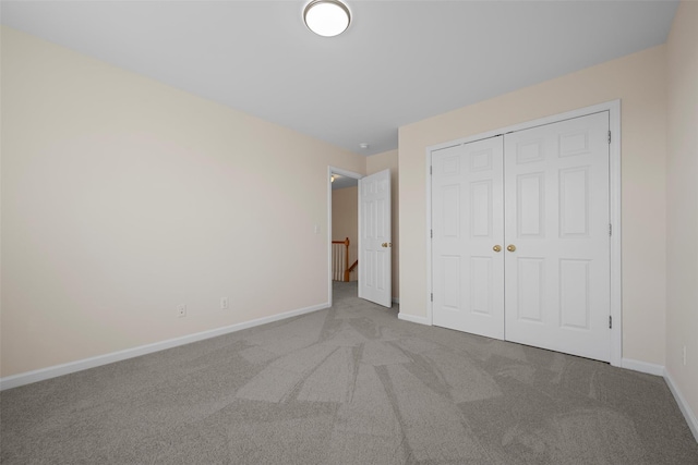 unfurnished bedroom featuring a closet, carpet, and baseboards