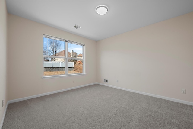 carpeted spare room featuring visible vents and baseboards