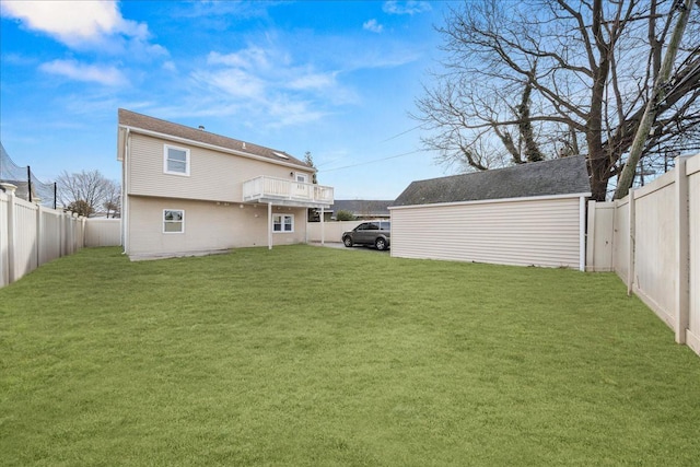 back of house with a yard and a fenced backyard