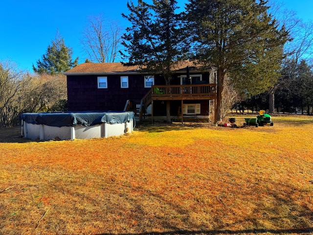 back of house with stairway, a covered pool, a lawn, and a deck