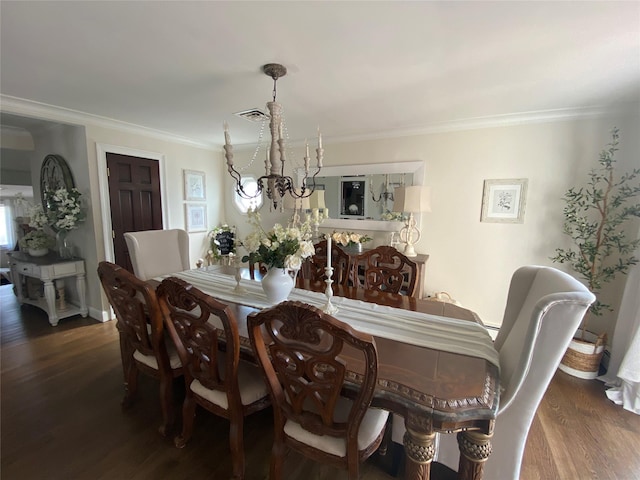 dining room with visible vents, ornamental molding, and wood finished floors