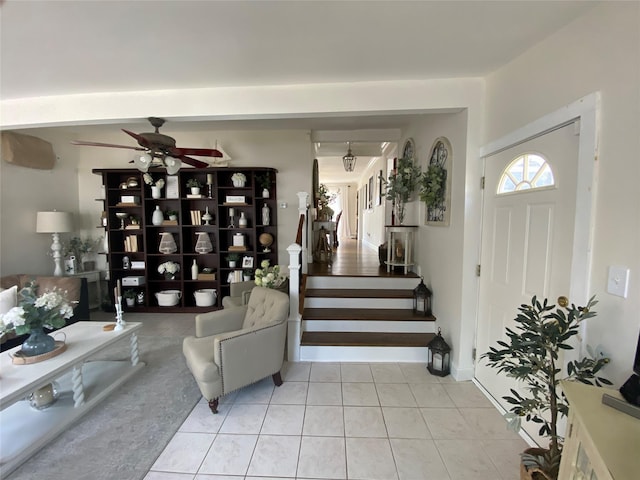 entrance foyer with stairs, a ceiling fan, and tile patterned flooring