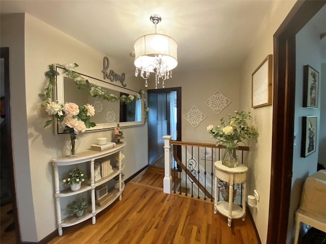 interior space featuring baseboards, a chandelier, and wood finished floors