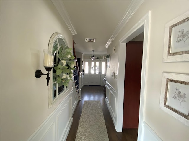 corridor with crown molding, visible vents, dark wood-type flooring, and a notable chandelier