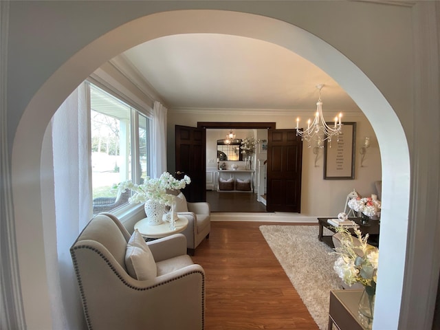 hall with arched walkways, ornamental molding, dark wood-style floors, and a chandelier