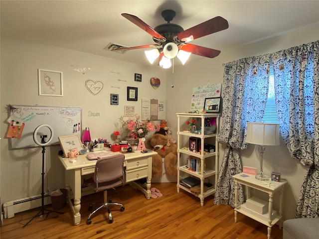 office with a ceiling fan, visible vents, baseboard heating, and wood finished floors