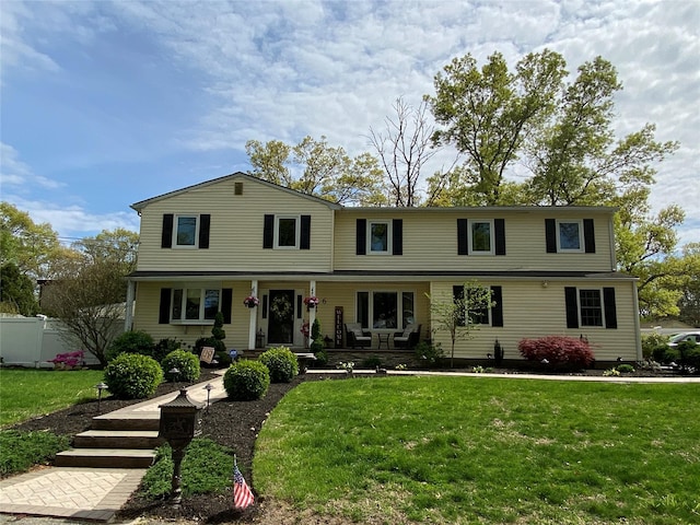 view of front of property with a front lawn, fence, and covered porch