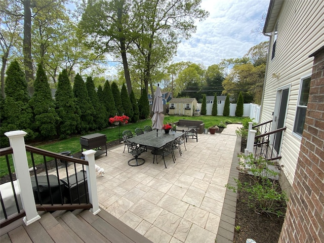 view of patio / terrace with an outbuilding, a storage shed, and outdoor dining space