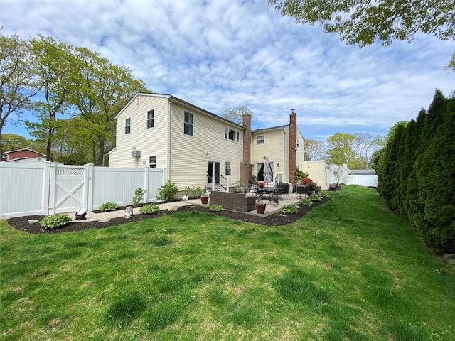 rear view of property featuring a gate, a patio area, a fenced backyard, and a yard