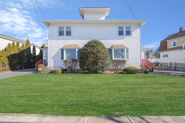 american foursquare style home featuring a front yard