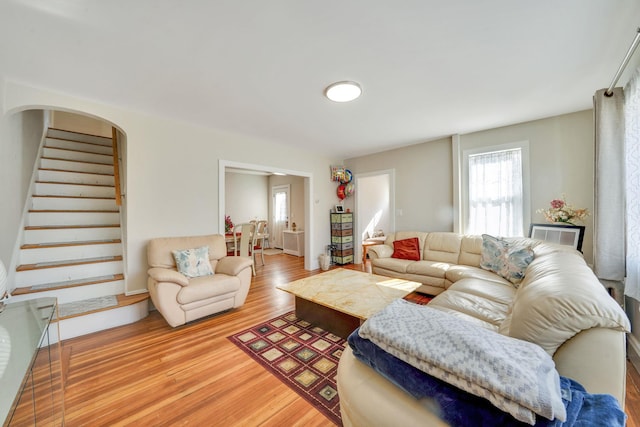 living area featuring stairs and light wood-style floors