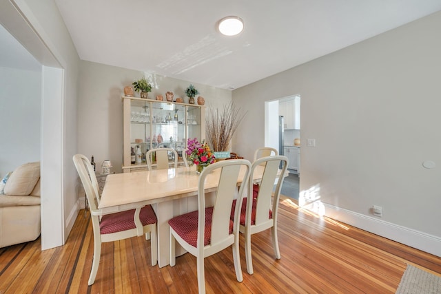 dining area featuring light wood finished floors and baseboards