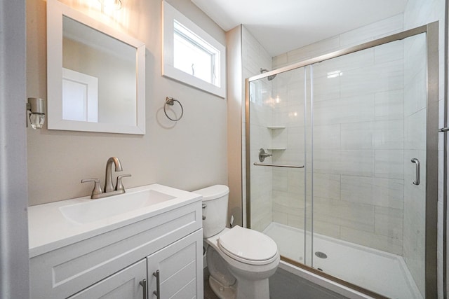 full bath with a stall shower, vanity, and toilet