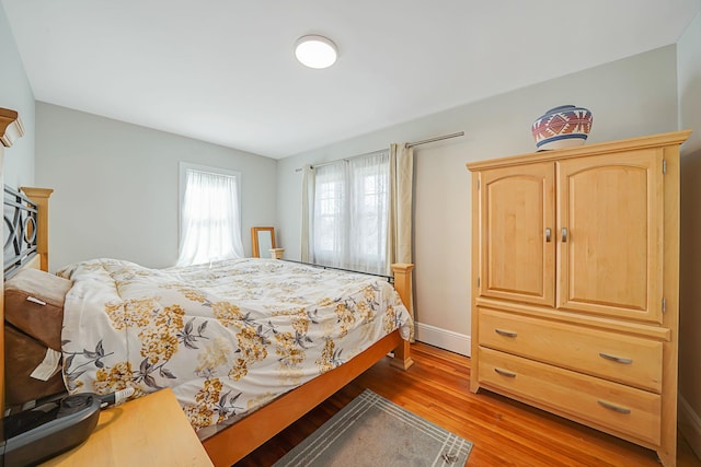 bedroom featuring baseboards and light wood finished floors