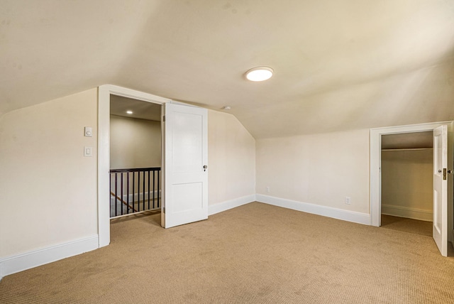 additional living space featuring carpet floors, baseboards, and lofted ceiling