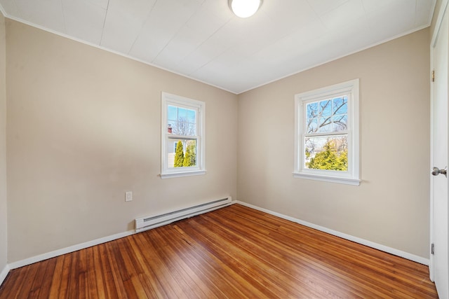 empty room featuring plenty of natural light, a baseboard radiator, hardwood / wood-style flooring, and baseboards