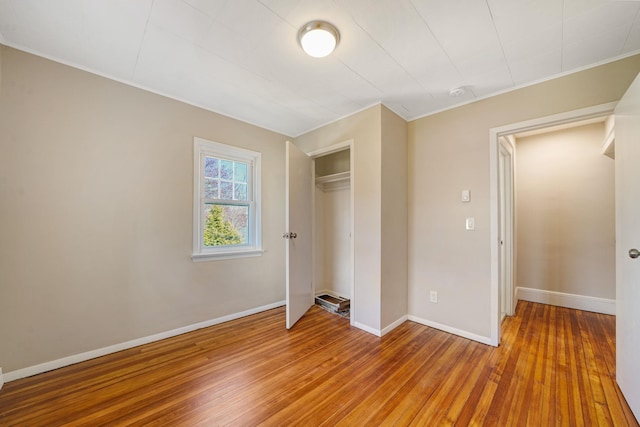 unfurnished bedroom featuring light wood-style floors, a closet, and baseboards