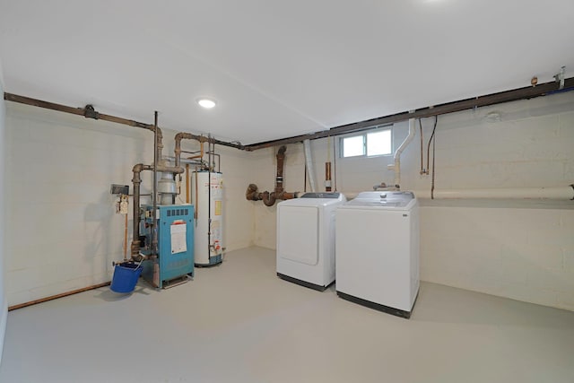 below grade area featuring water heater, a heating unit, and washing machine and clothes dryer