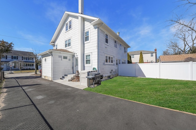 back of property with fence and a lawn