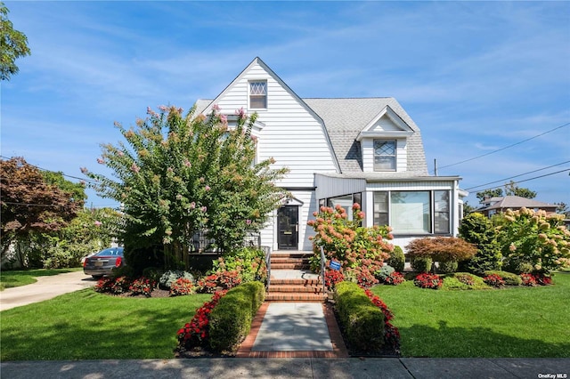 view of front of house featuring a gambrel roof and a front yard