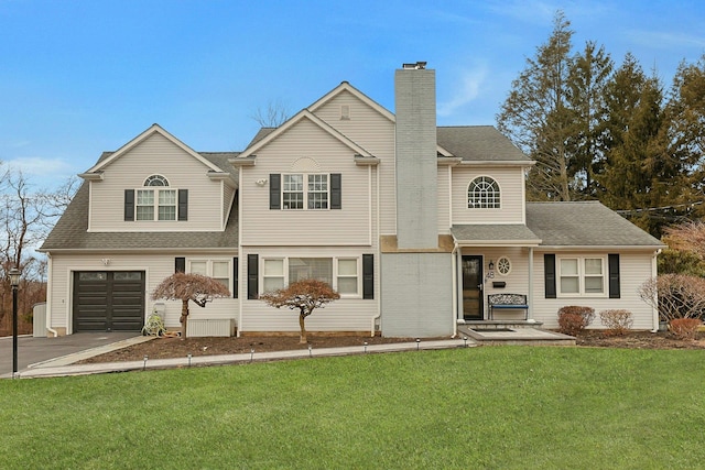 view of front of house with driveway, a shingled roof, a chimney, an attached garage, and a front yard