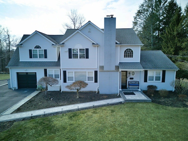 view of front facade featuring a chimney, a shingled roof, a front yard, a garage, and driveway