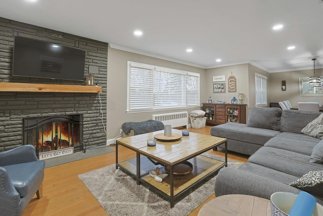 living area with recessed lighting, a fireplace, wood finished floors, ornamental molding, and radiator