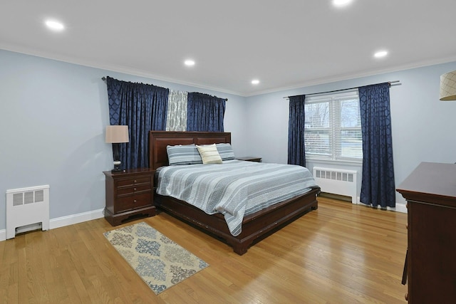 bedroom with light wood-type flooring, crown molding, and radiator heating unit