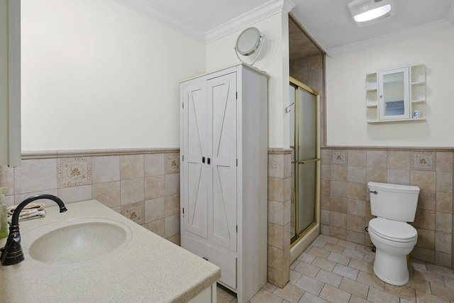 bathroom featuring a shower stall, a sink, tile walls, and crown molding