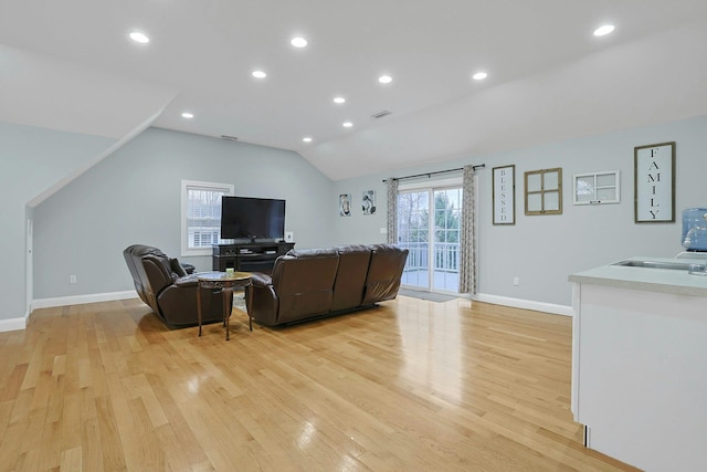 living area with recessed lighting, visible vents, light wood-style floors, vaulted ceiling, and baseboards