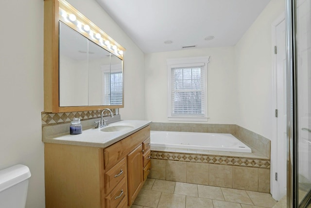 bathroom with tile patterned flooring, a garden tub, visible vents, vanity, and decorative backsplash