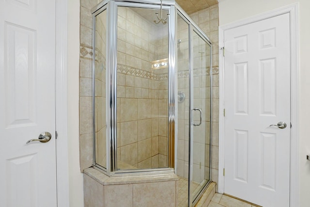 bathroom with a stall shower and tile patterned floors