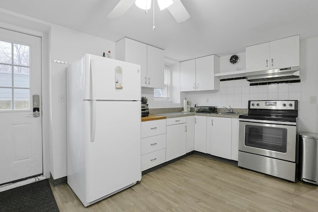 kitchen featuring light wood-style floors, freestanding refrigerator, white cabinets, under cabinet range hood, and stainless steel electric range