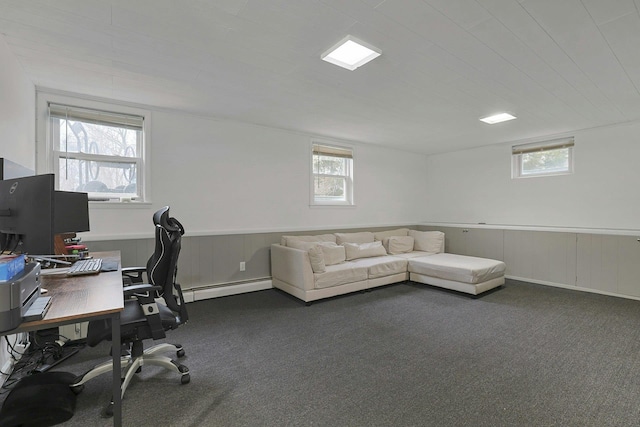 office space with a baseboard heating unit, dark colored carpet, and wainscoting