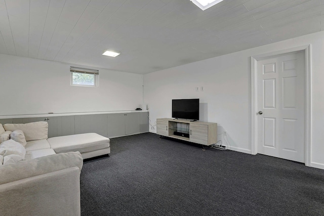 unfurnished living room with dark colored carpet and baseboards