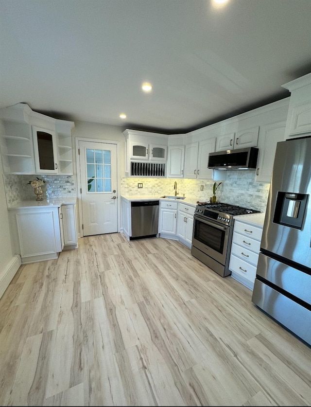 kitchen featuring a sink, white cabinetry, light countertops, appliances with stainless steel finishes, and open shelves