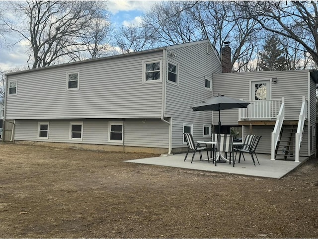 back of property featuring stairs and a patio