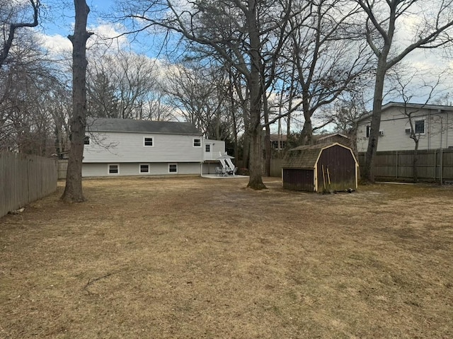 view of yard featuring an outbuilding, fence, and a shed