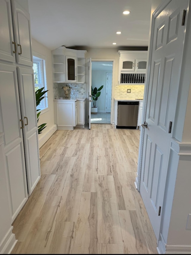 kitchen with open shelves, decorative backsplash, white cabinets, light wood-type flooring, and dishwasher