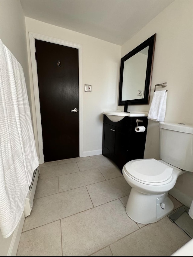 bathroom featuring baseboards, vanity, toilet, and tile patterned floors