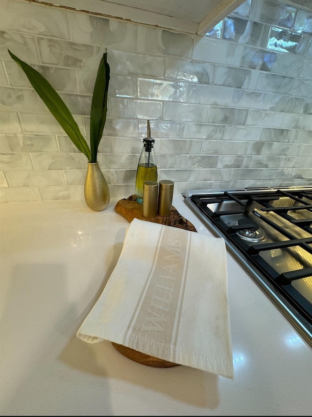 interior details with stainless steel gas stovetop and decorative backsplash