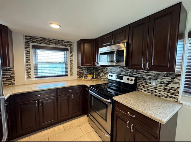 kitchen featuring dark brown cabinetry, decorative backsplash, stainless steel appliances, and light countertops