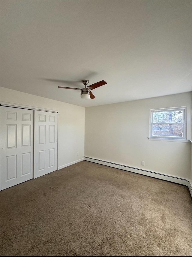 unfurnished bedroom featuring ceiling fan, baseboards, baseboard heating, a closet, and carpet