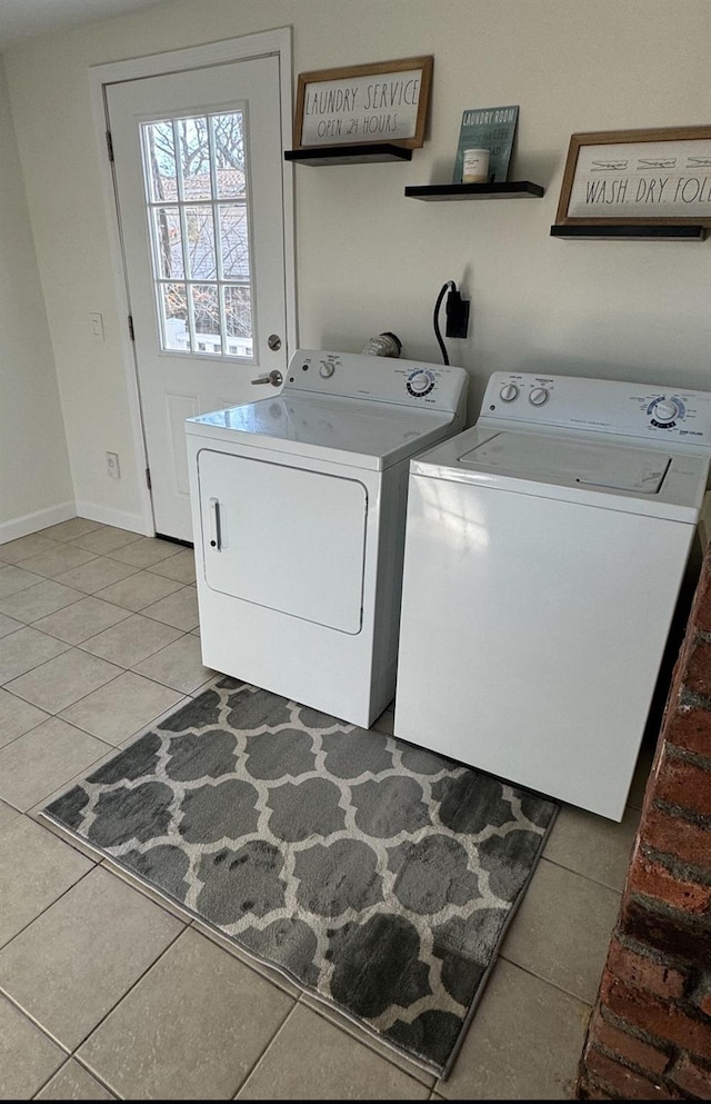 washroom with washing machine and dryer, laundry area, baseboards, and light tile patterned floors