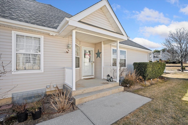 doorway to property with roof with shingles