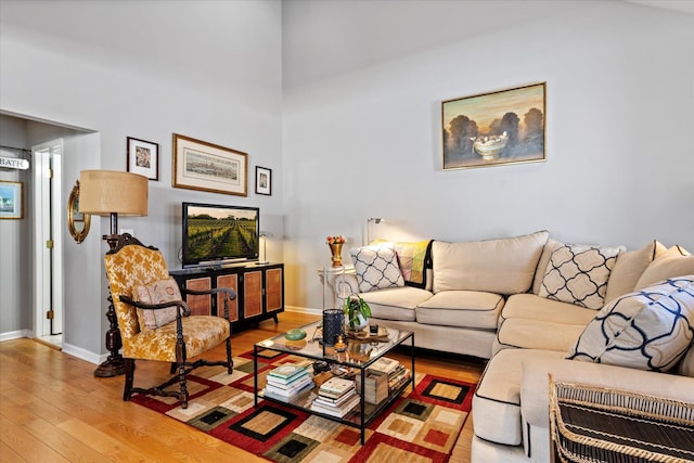 living area with wood-type flooring and baseboards