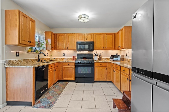 kitchen with a sink, black appliances, light tile patterned floors, and backsplash