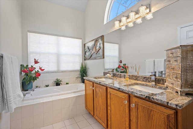 bathroom featuring a bath, tile patterned flooring, double vanity, and a sink