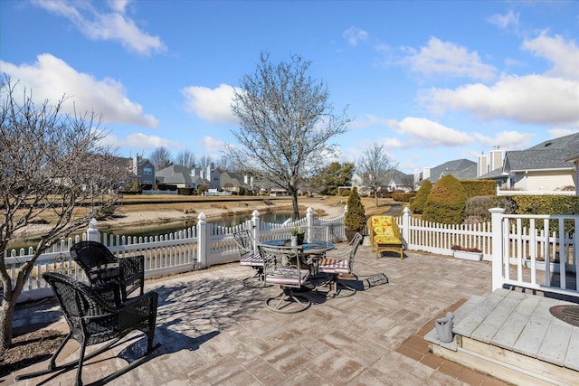 view of patio / terrace featuring a residential view, outdoor dining area, and fence