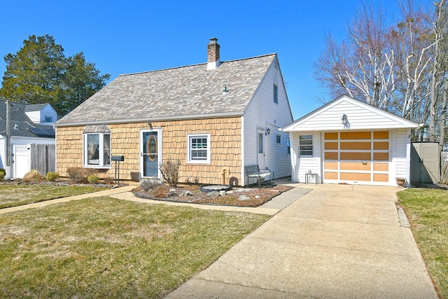 view of front of property featuring fence, concrete driveway, a front yard, a chimney, and an outbuilding